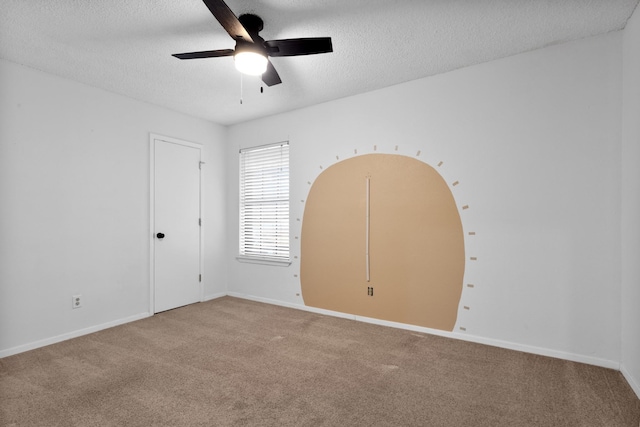 carpeted spare room featuring ceiling fan and a textured ceiling