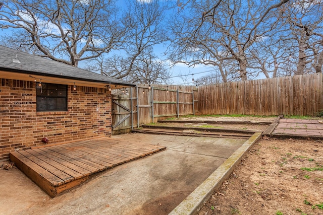 view of yard featuring a wooden deck and a patio area