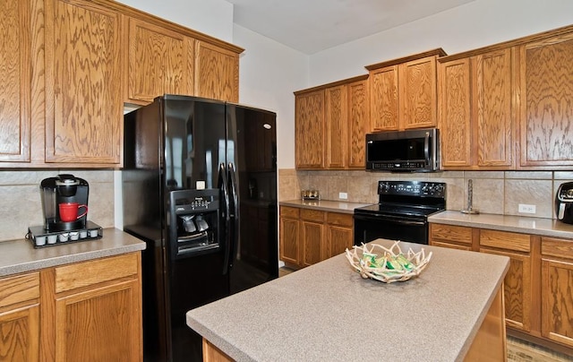 kitchen featuring tasteful backsplash, black appliances, and a center island