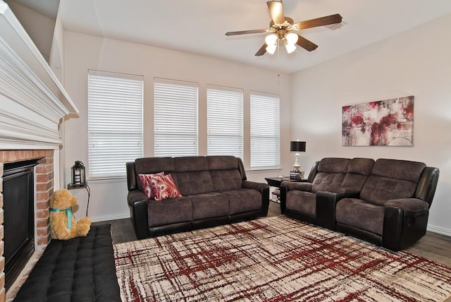 living room with wood-type flooring, a brick fireplace, and ceiling fan