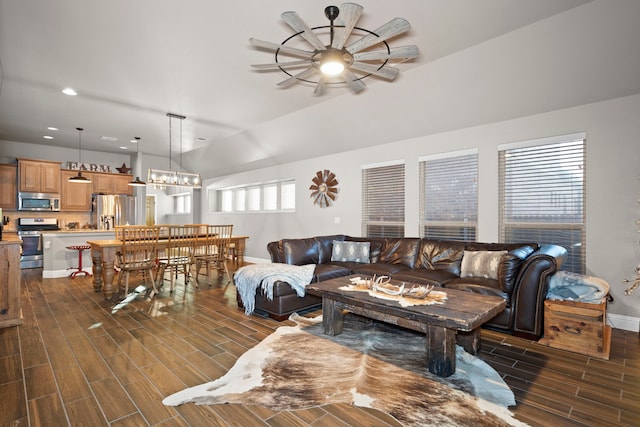 living room with ceiling fan with notable chandelier