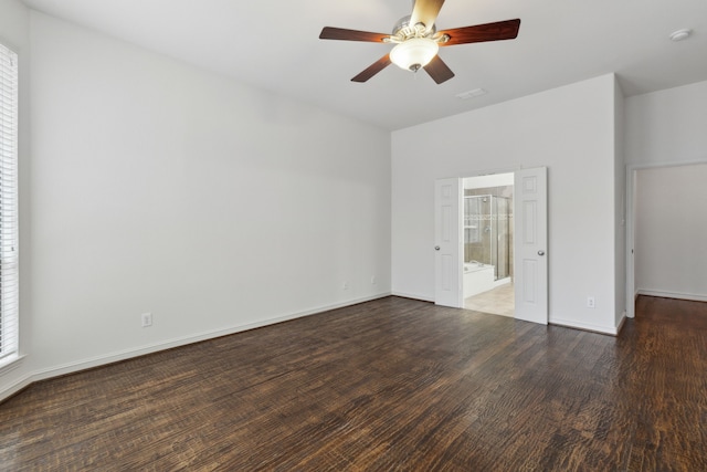 unfurnished bedroom with ensuite bathroom, dark wood-type flooring, and ceiling fan