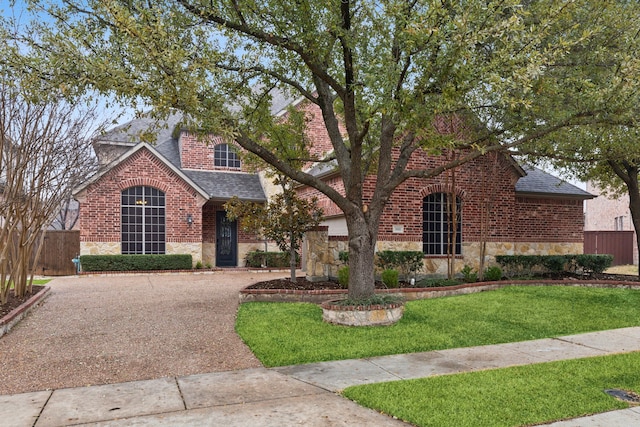 900 Thimbleberry Dr, Mckinney, TX 75071 - view of front of house with brick siding, a front lawn, a shingled roof, and stone siding