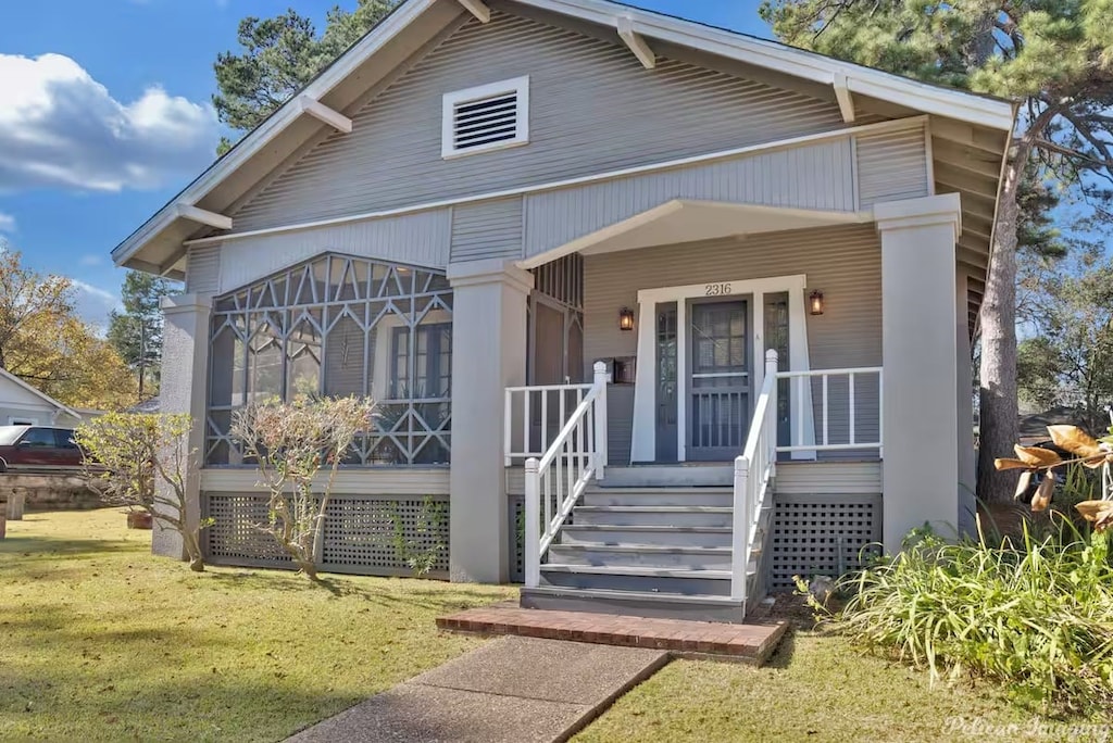 view of front of home with a porch and a front lawn