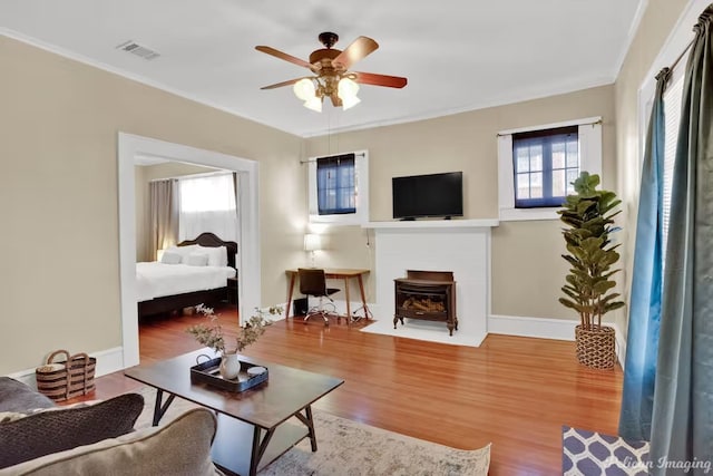 living room featuring hardwood / wood-style flooring, ceiling fan, and ornamental molding