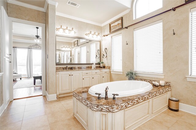 bathroom with tile patterned floors, ornamental molding, a bathing tub, and vanity