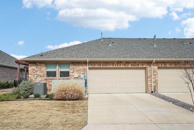 ranch-style home featuring a garage, central AC unit, and a front yard