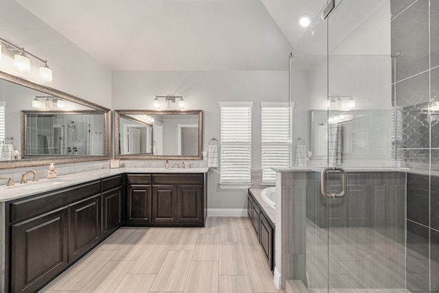 bathroom with vanity, separate shower and tub, and vaulted ceiling