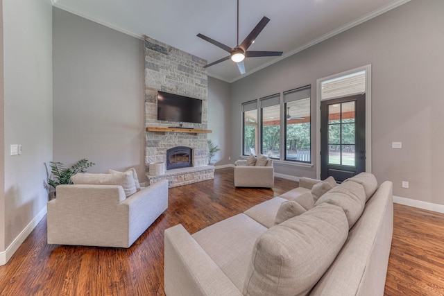 living room featuring ornamental molding, dark wood-type flooring, ceiling fan, and a fireplace