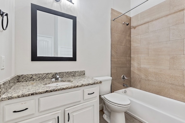 full bathroom featuring tiled shower / bath, vanity, and toilet