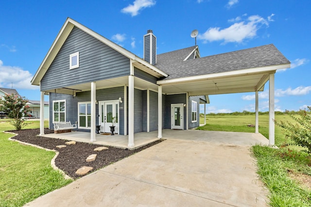 back of property with french doors, a yard, and covered porch