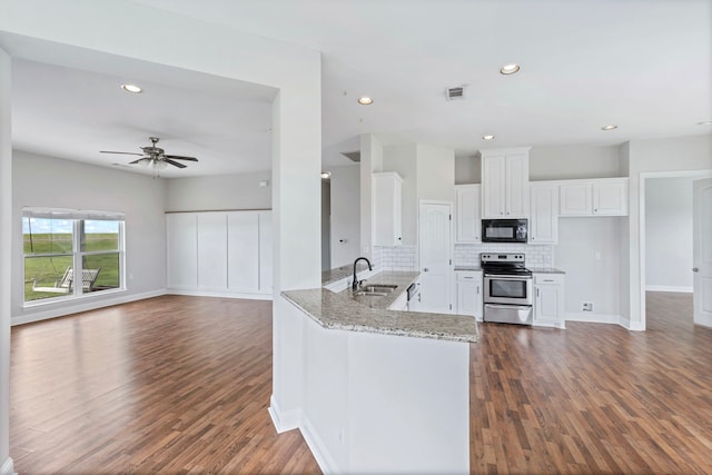 kitchen with sink, tasteful backsplash, white cabinets, stainless steel range with electric cooktop, and kitchen peninsula