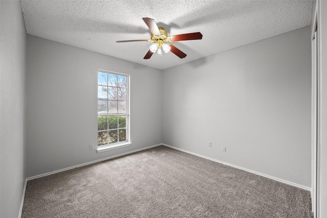 carpeted empty room with ceiling fan and a textured ceiling