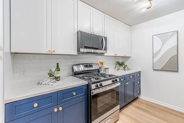 kitchen with stainless steel appliances, white cabinets, blue cabinets, decorative backsplash, and light wood-type flooring