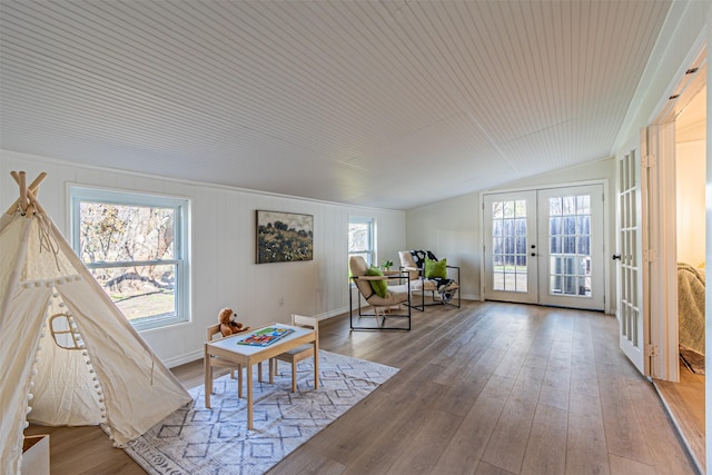 living area featuring french doors, vaulted ceiling, hardwood / wood-style floors, and a wealth of natural light