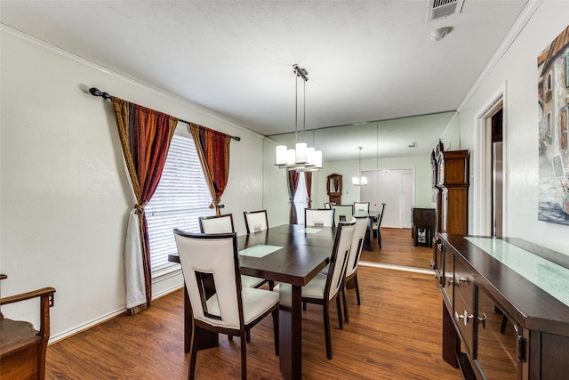 dining space featuring dark hardwood / wood-style flooring, a notable chandelier, and crown molding