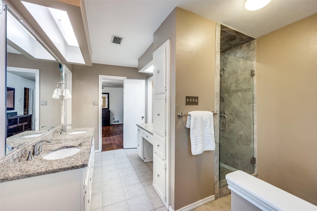 bathroom featuring vanity, a shower with shower door, and tile patterned floors