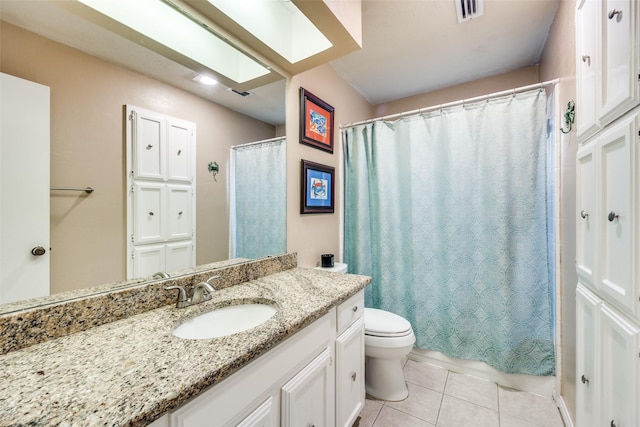 bathroom with vanity, toilet, tile patterned floors, and a skylight