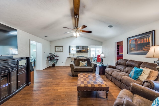 living room with hardwood / wood-style flooring, ceiling fan, and lofted ceiling with beams