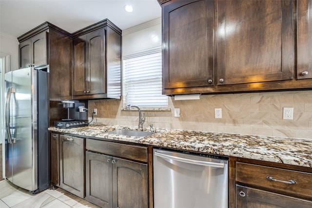 kitchen with stainless steel appliances, sink, dark brown cabinetry, and light stone counters