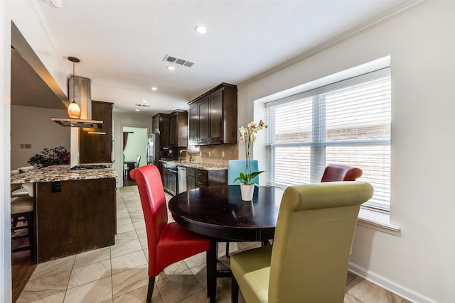 tiled dining room featuring sink and ornamental molding