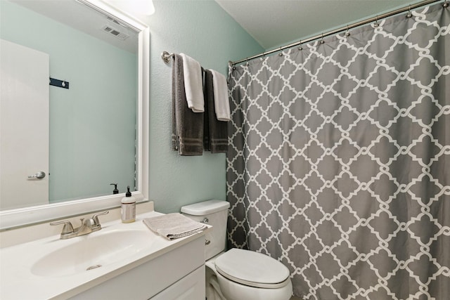 bathroom featuring a shower with curtain, vanity, and toilet