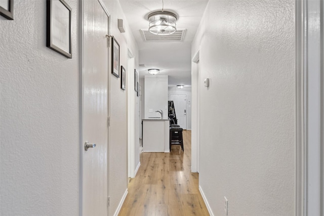 corridor with light hardwood / wood-style flooring