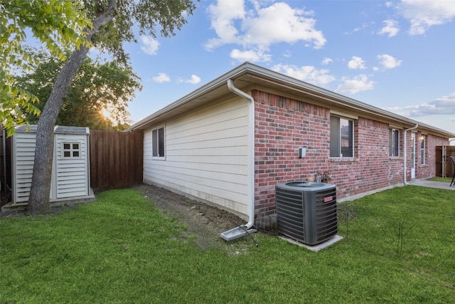 view of property exterior featuring a yard, a shed, and central air condition unit