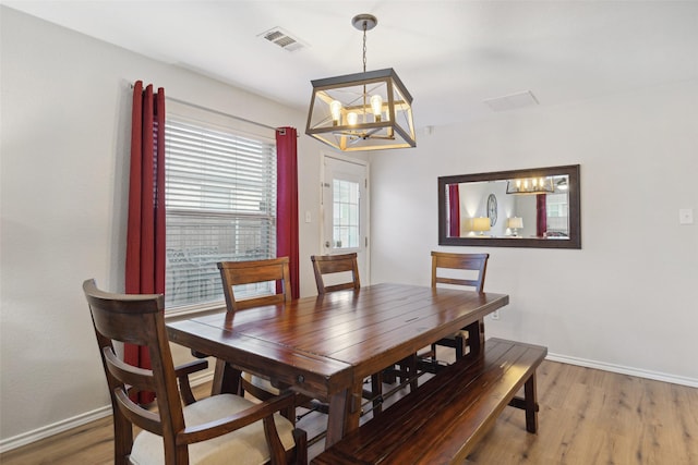 dining area with an inviting chandelier and hardwood / wood-style floors