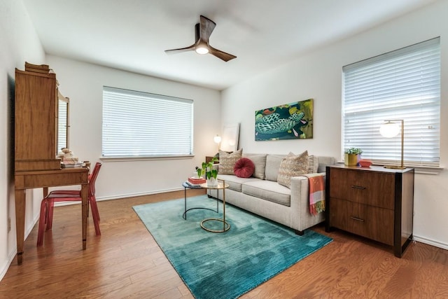 living room with dark wood-type flooring and ceiling fan