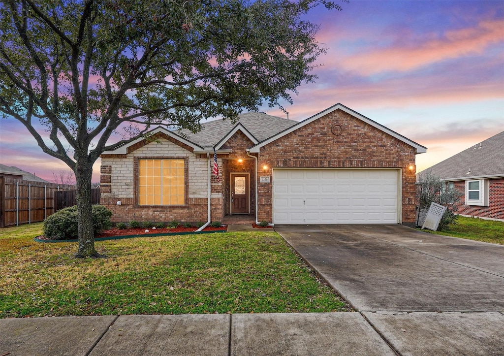 single story home featuring a garage and a lawn