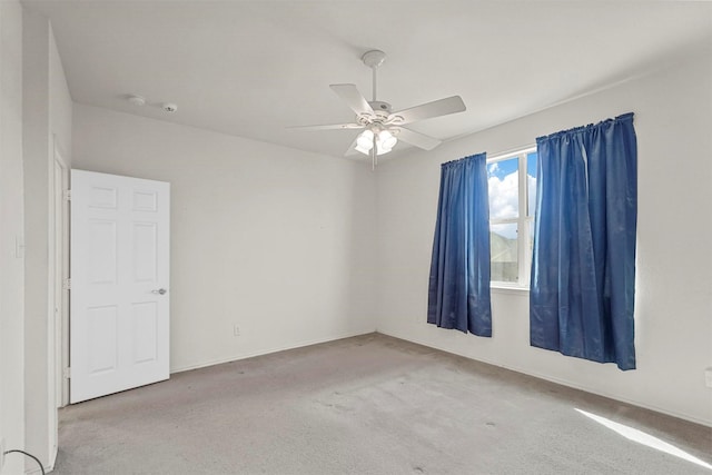 empty room featuring ceiling fan and carpet