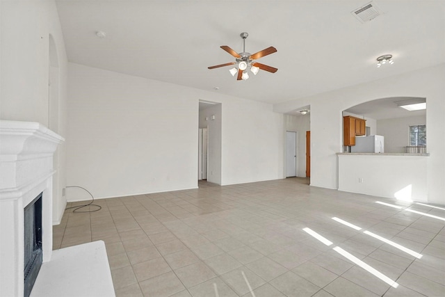 unfurnished living room featuring light tile patterned floors and ceiling fan