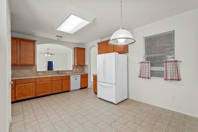 kitchen featuring sink, white appliances, ceiling fan, hanging light fixtures, and backsplash