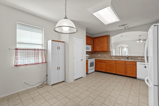 kitchen with sink, white appliances, ceiling fan, hanging light fixtures, and decorative backsplash