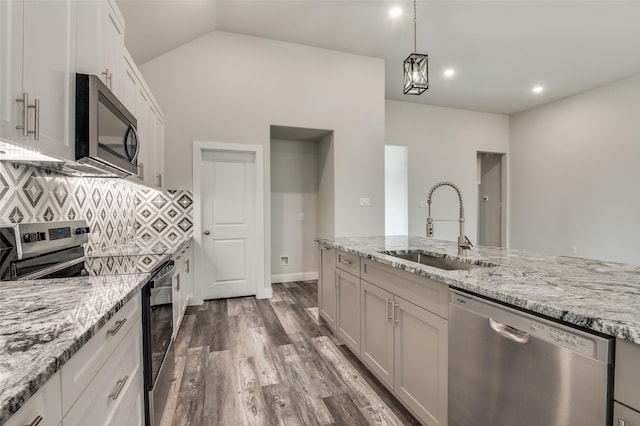 kitchen featuring stainless steel appliances, light stone countertops, sink, and white cabinets