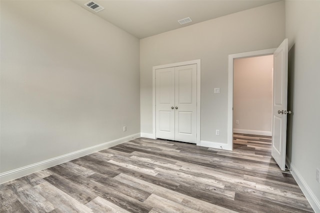 unfurnished bedroom with hardwood / wood-style floors and a closet