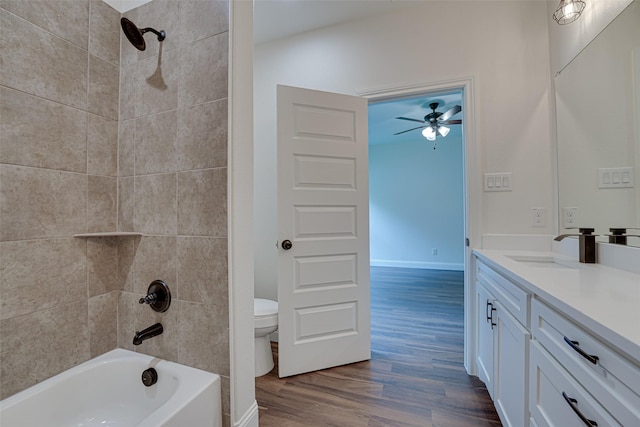 full bathroom featuring vanity, tiled shower / bath combo, wood-type flooring, and toilet