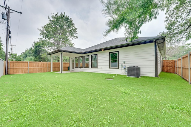 back of property with a yard and central AC