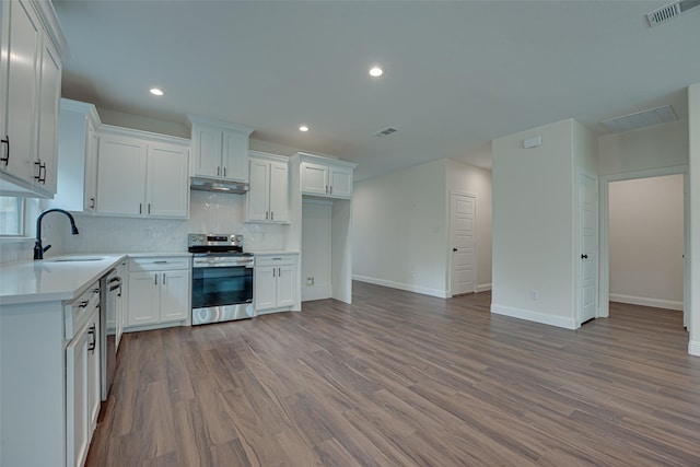 kitchen featuring appliances with stainless steel finishes, tasteful backsplash, white cabinetry, sink, and light hardwood / wood-style flooring