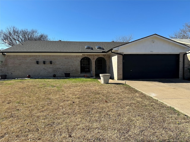 ranch-style home with a garage and a front lawn