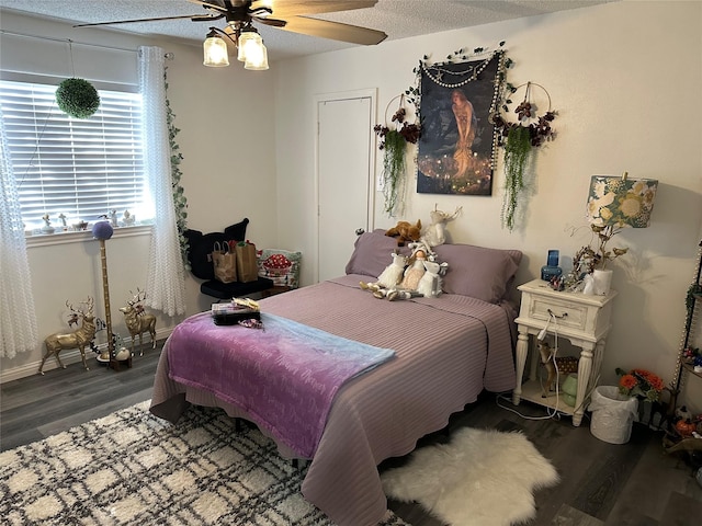 bedroom featuring a textured ceiling, dark wood-type flooring, and ceiling fan