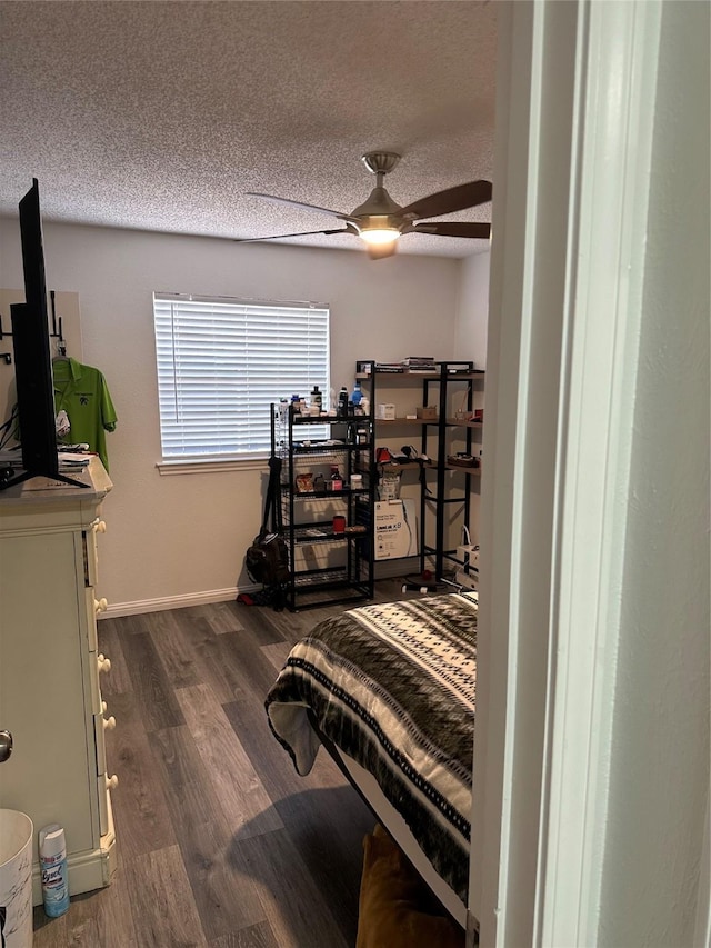 bedroom featuring ceiling fan, dark hardwood / wood-style floors, and a textured ceiling