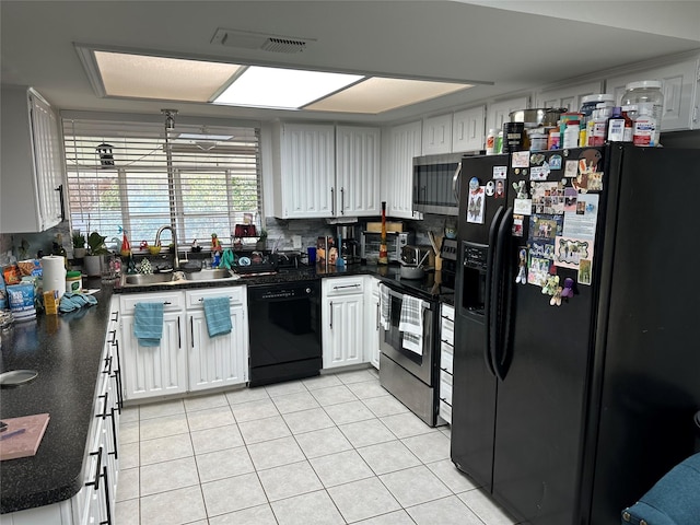 kitchen with sink, white cabinets, decorative backsplash, light tile patterned floors, and black appliances