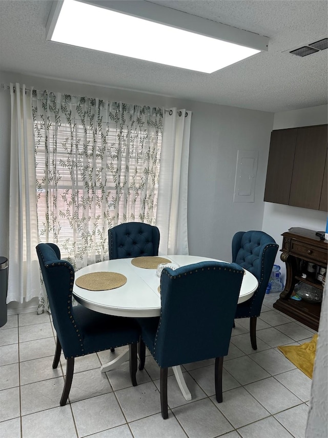 dining room with light tile patterned floors and a textured ceiling