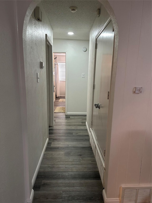 hallway featuring dark hardwood / wood-style floors and a textured ceiling