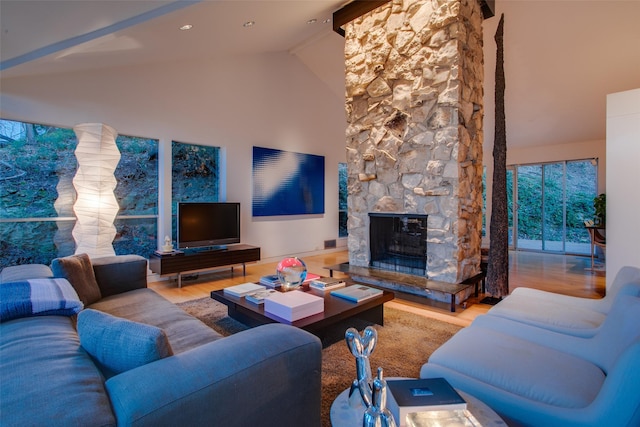 living room featuring a fireplace, high vaulted ceiling, and light hardwood / wood-style flooring