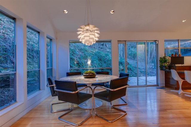 dining area featuring an inviting chandelier and light hardwood / wood-style floors