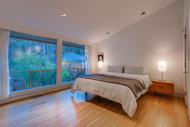 bedroom featuring lofted ceiling and light wood-type flooring