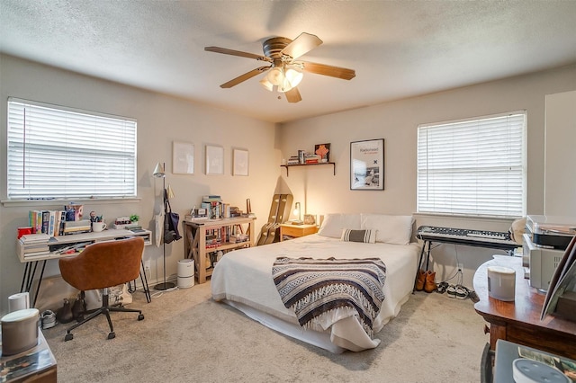 carpeted bedroom featuring ceiling fan and a textured ceiling